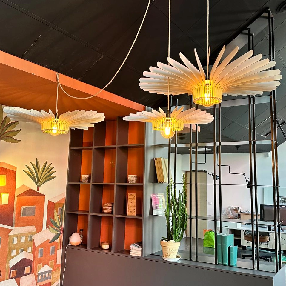 Angle de vue de la suspension kaze triple éclairé dans un showroom avec bibliothèque en métal en fond